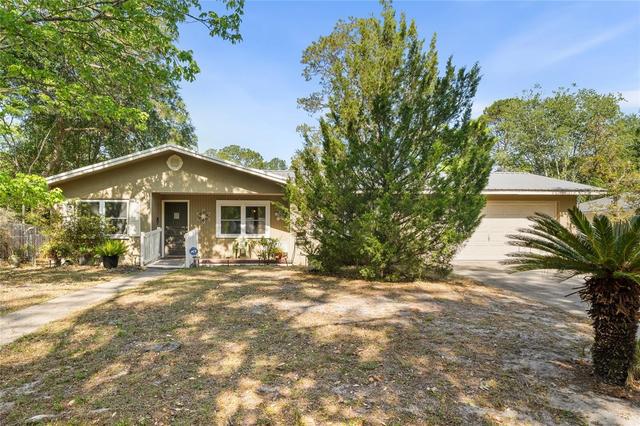 Tan stucco home with landscaped front yard in Live Oak, Florida