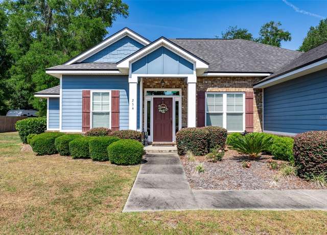 Blue cottage-style home with landscaped front yard in High Springs